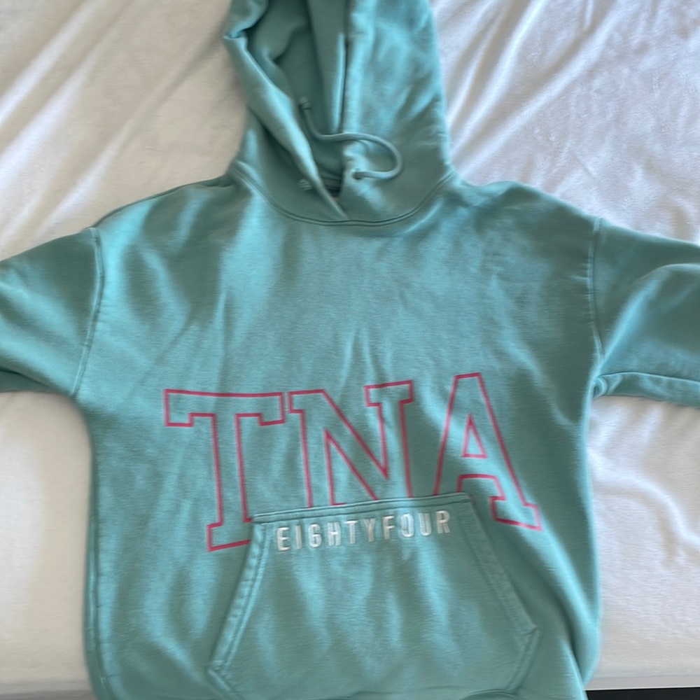 Hoodie sweater TNA, turquoise blue with pink lettering